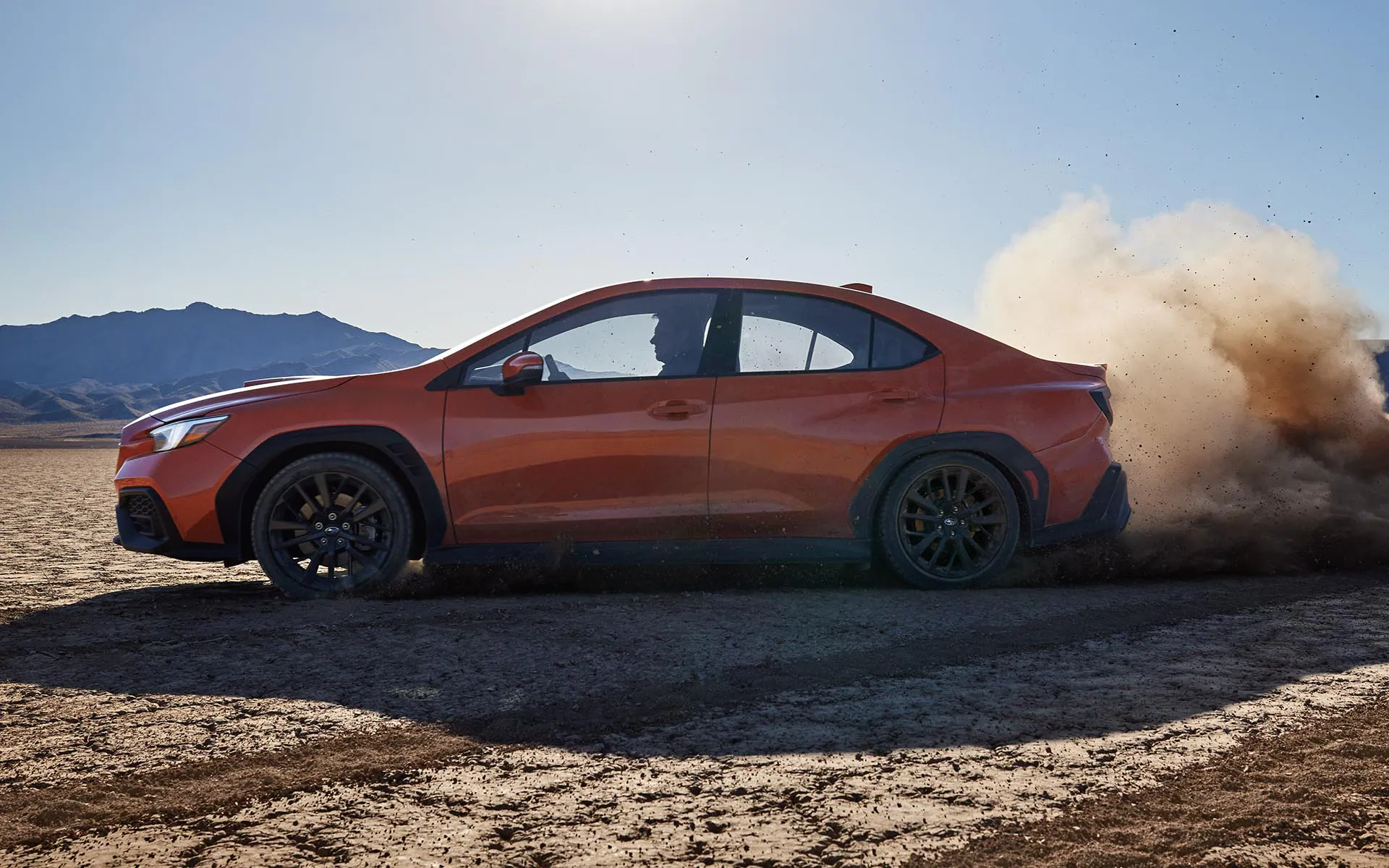 The 2022 Subaru kicking up dirt while driving on a desert road
